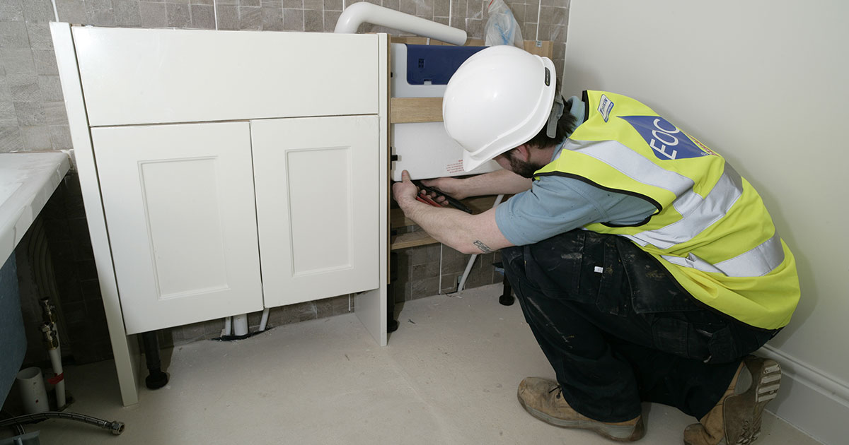 EOC Engineer working inside bathroom to install air to water heat pumps